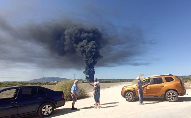 Medios terrestres y aéreos trabajan en la extinción de un incendio en una nave de Murcia