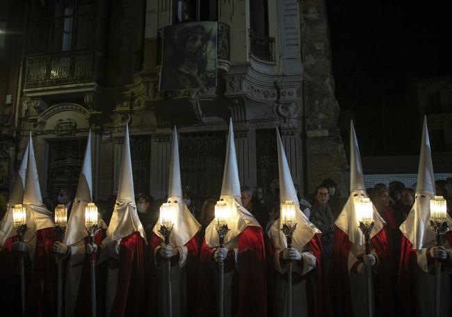 Penitentes de San Juan desfilando con sus prismas, los hachotes a gas butano.