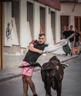 Imagen secundaria 2 - Un mozo realiza un recorte a una de las vacas durante el encierro. Pase de pecho con un capote improvisado.