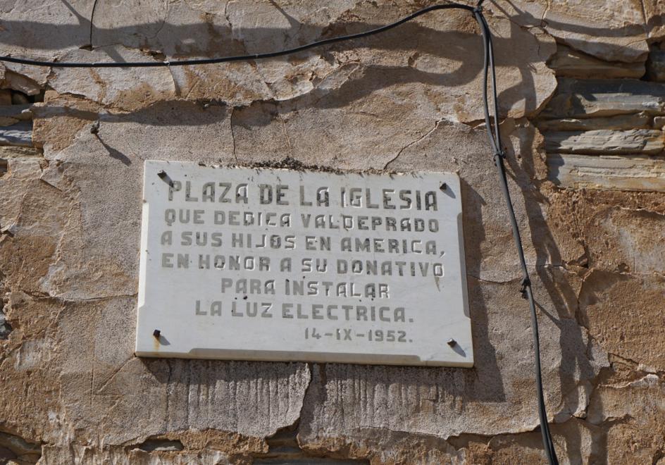 Placa colocada en 1952 en la plaza de la iglesia de Valdeprado en honor a «sus hijos en América» por su donativo para instalar luz eléctrica.