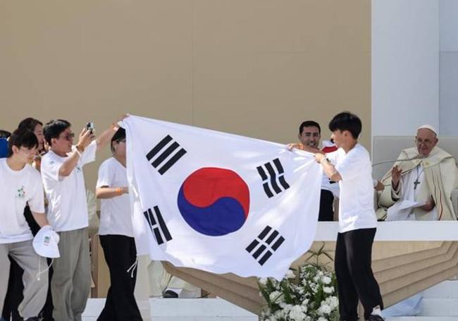 Varios jóvenes con la bandera de Corea del Sur junto al Papa.