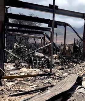 Imagen secundaria 2 - Arriba, una escena nocturna del incendio en Maui. Abajo, la carretera que conduce al Lahaina, el pueblo más afectado por las llamas. Al lado, una de las viviendas afectadas