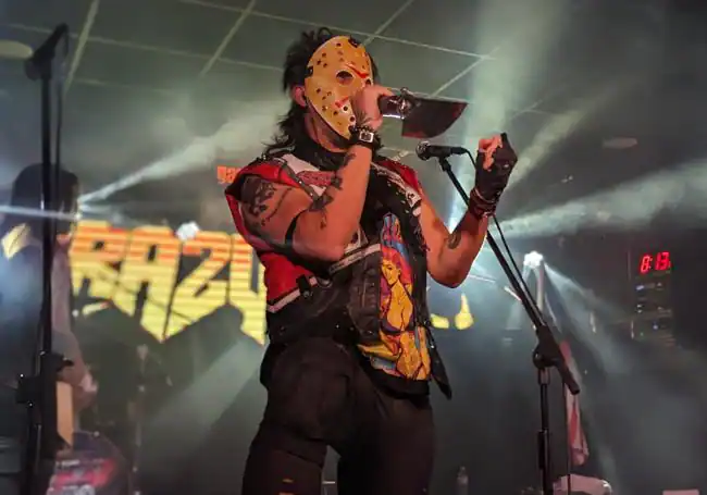 Danny Rexon, cantante de Crazy Lixx, ataviado con una máscara de Jason Vorhees y un machete-micrófono.