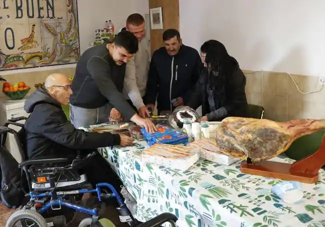 Usuarios y miembros de El Buen Camino de Lorca preparan los productos para la cena.