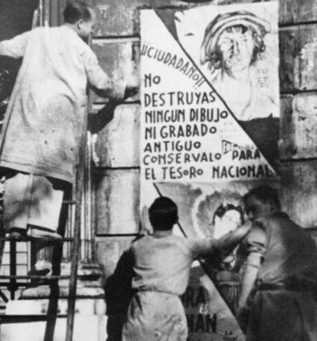 Alumnos de la Escuela de Bellas Artes fijando los carteles originales, ejecutados por ellos mismos, en defensa del tesoro artístico.