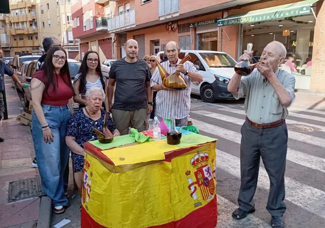 Pepe y Marita, del mesón Los Pepes, ofrecen bebida y galleta a los romeros.