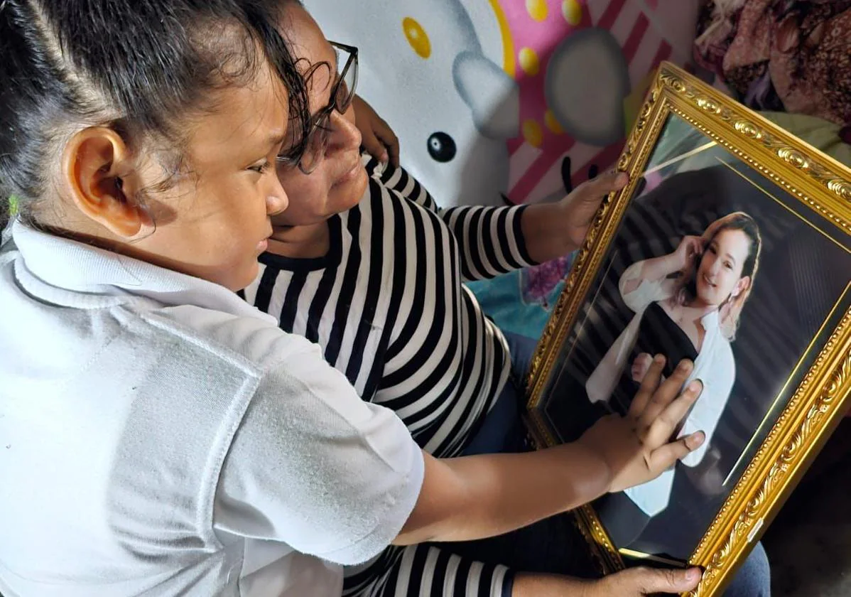 Celeste mira un retrato de su madre Orfilia junto a su abuela Milagros en su casa de Nicaragua.