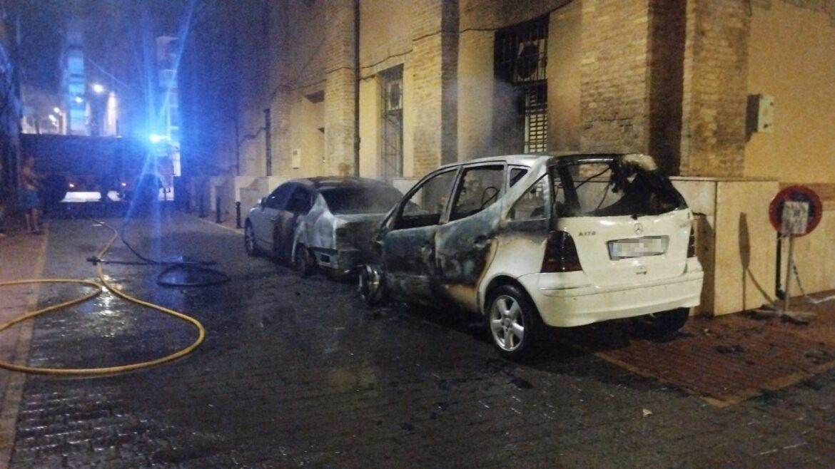 Coches calcinados por el incendio de tres contenedores tras el inicio de las fiestas de La Unión