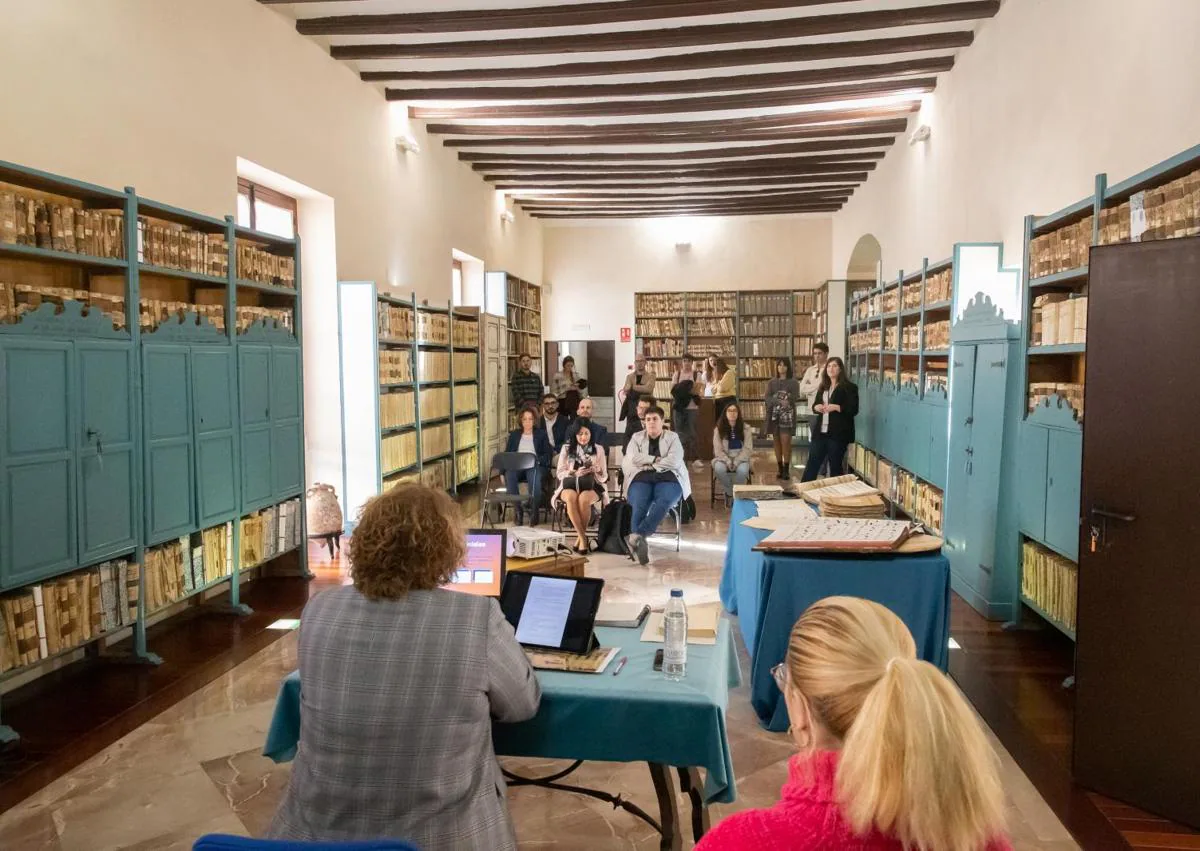 Imagen secundaria 1 - La profesora Inmaculada Dolón imparte su taller y muestra a los presentes algunas de las partituras más valiosas del archivo.