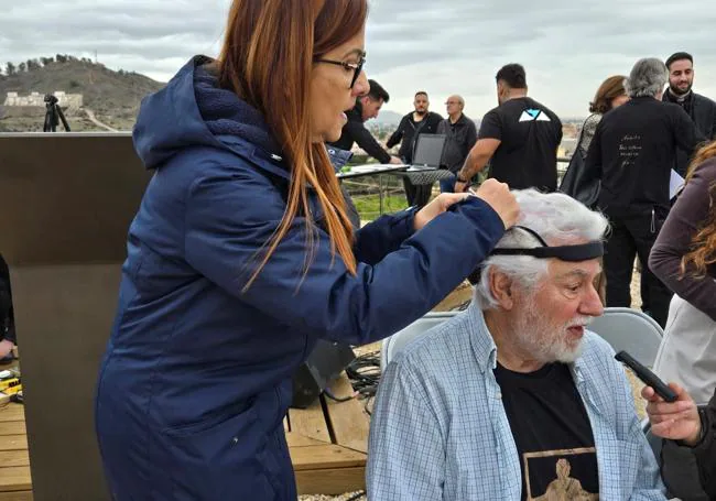 Colocación de un casco de neurometría en la cabeza del artista para registrar sus constantes cerebrales durante el proceso creativo