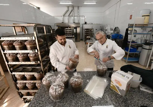 Padre e hijo terminan de empaquetar los 'panettones'.