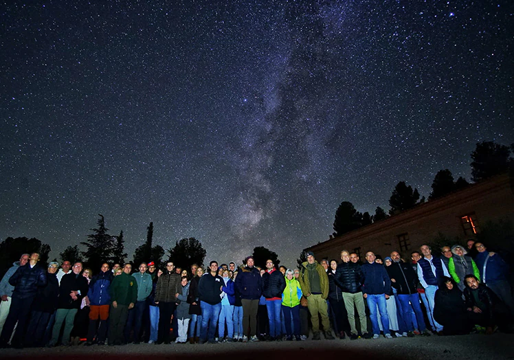 Un grupo de aficionados a la astronomía posa junto al monasterio de Santa María del Olivar, en Estercuel (Teruel), que organiza observaciones de uno de los cielos estrellados más limpios de Europa.