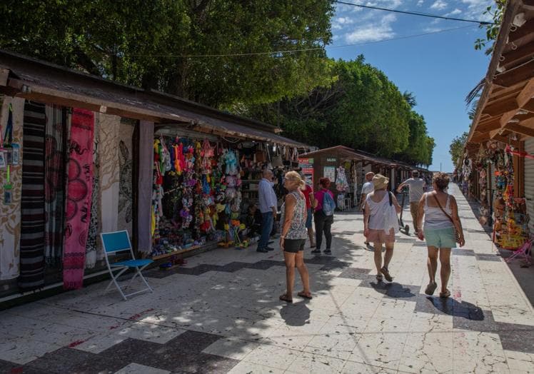 Turistas visitan los puestos del mercadillo de los 'hippies', junto al puerto.