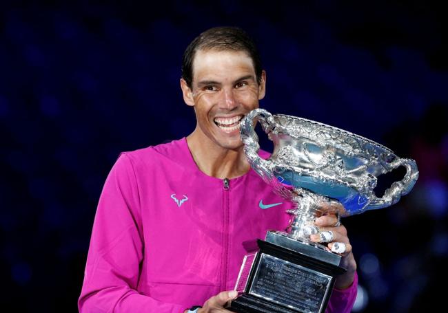 Rafa Nadal muerde el trofeo del Open de Australia tras conquistarlo en 2022.