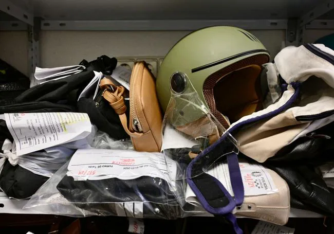 Un casco guardado entre bolsos extraviados, en una de las estanterías del departamento de Objetos Perdidos de la Policía Local de Murcia.