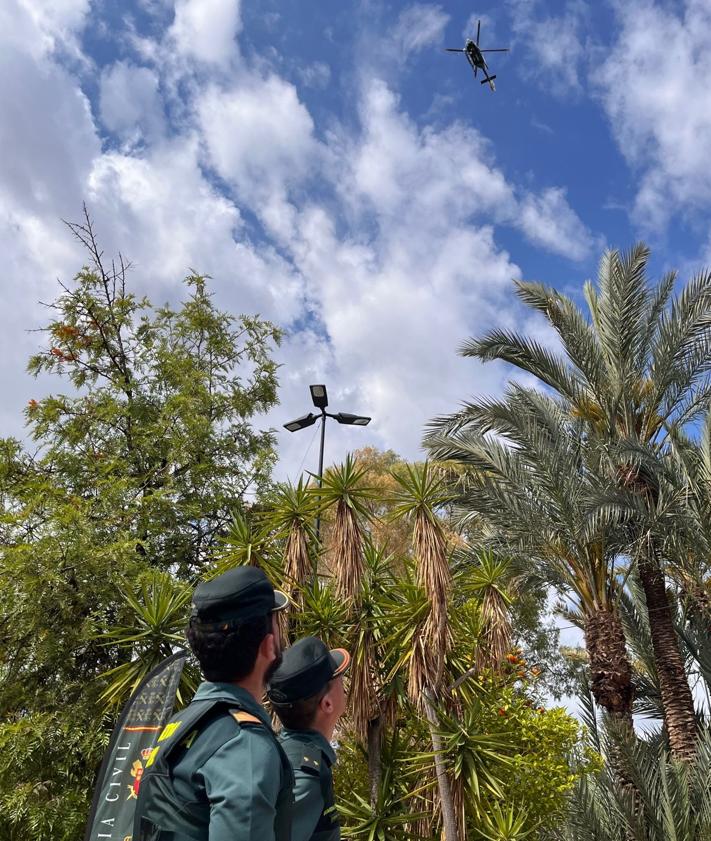 Imagen secundaria 2 - Izquierda: La delegada del Gobierno, junto a la alcaldesa de Alhama, acompañadas por el Coronel Jefe de la Benemerita atendiendo explicaciones de como se realiza un control de drogas. Derecha: Helicóptero de la Guardia Civil sobrevolando la muestra.