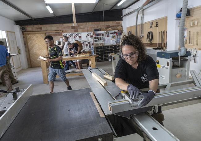 Los asistentes al taller de carpintería, en plena faena.