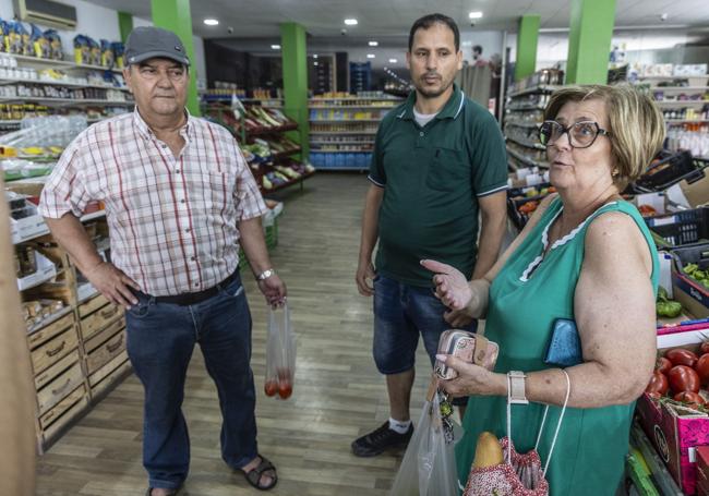 El comerciante Said Achquir (en el centro), charlando con los clientes Antonio Grau y Carmen Tomás, el pasado jueves en la Frutería 3 Hermanos de Torre Pacheco.
