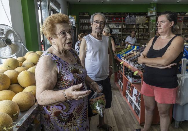 María Francisca López, Sebastián Martínez y Pilar Fernández, charlando junto a una estantería con melones.
