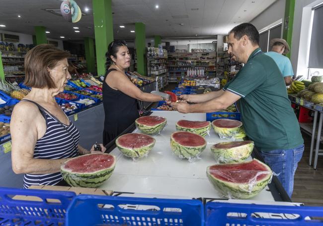 Achquir, que está en el pueblo desde 2003 y cuyo padre llegó en 1995 para trabajar en el campo, ayuda a dos mujeres a elegir sandía.