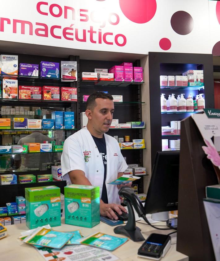 Imagen secundaria 2 - Arriba, el cartel que indica la entrada al vertedero. Abajo, una mujer caminando con la mascarilla por el humo y una farmacia de A Rúa.