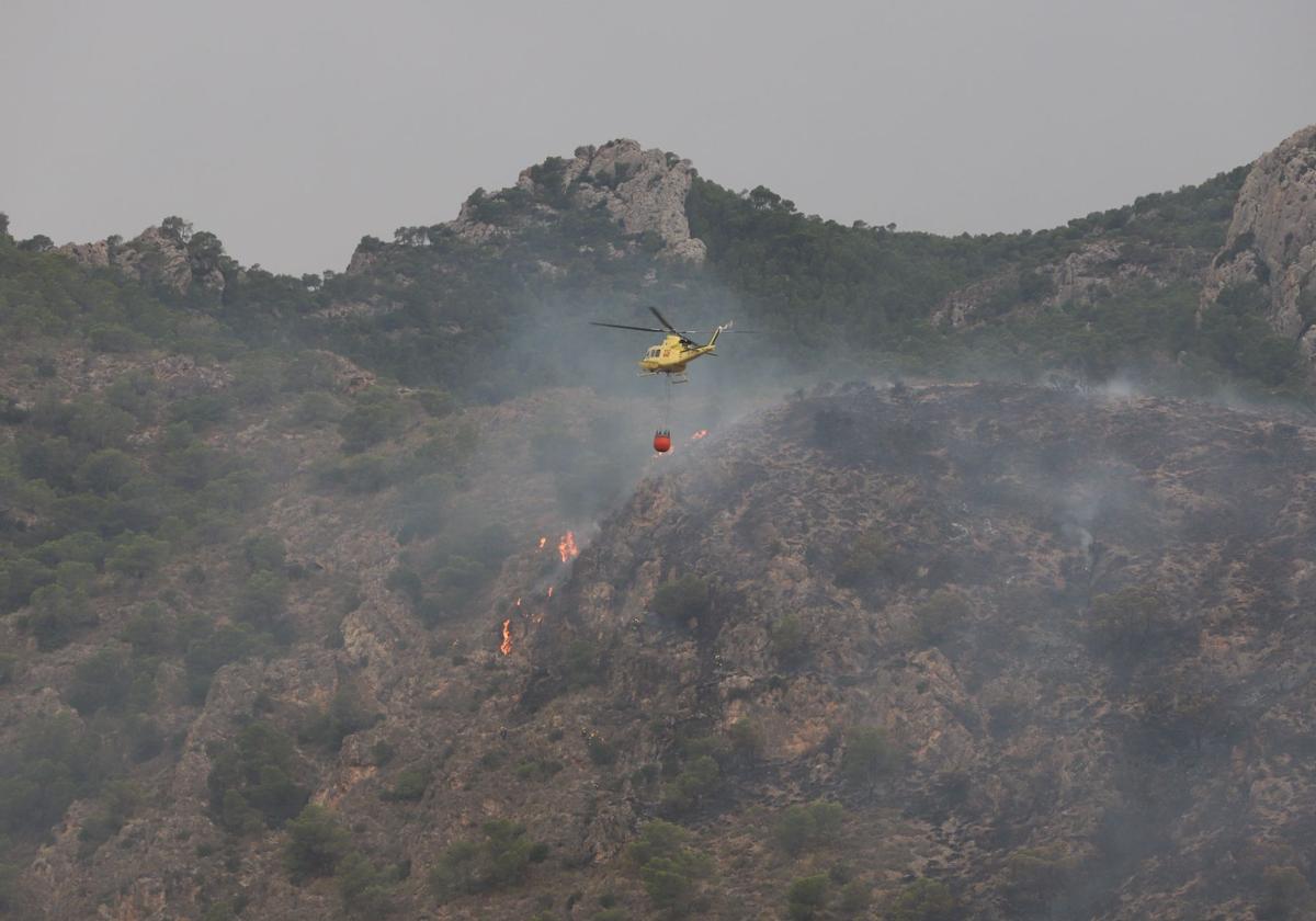 Un helicóptero lanza agua sobre las llamas en el incendio de Abarán.