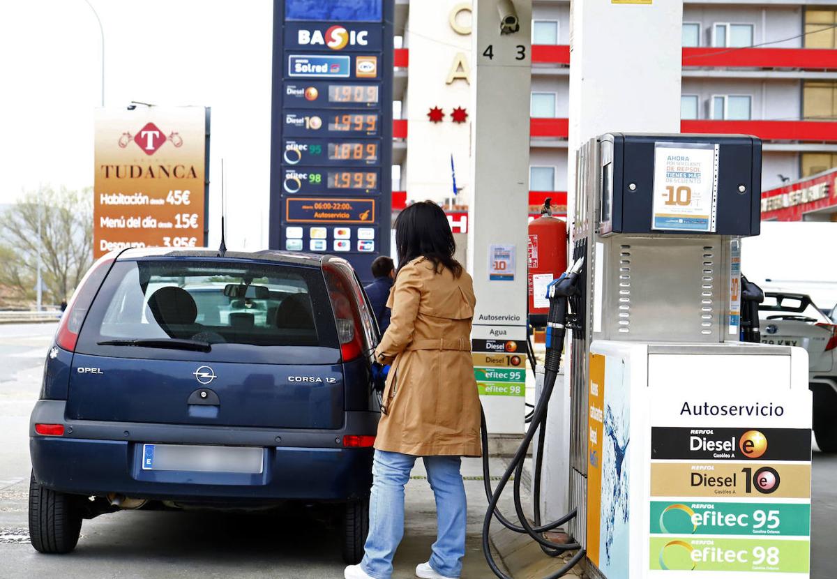 Una mujer echa gasolina al coche.
