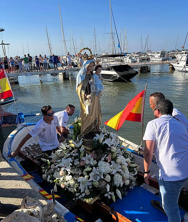 Imagen secundaria 2 - La imagen de la patrona de Los Urrutias, frente a la iglesia y montada en un barco durante el día de su romería.
