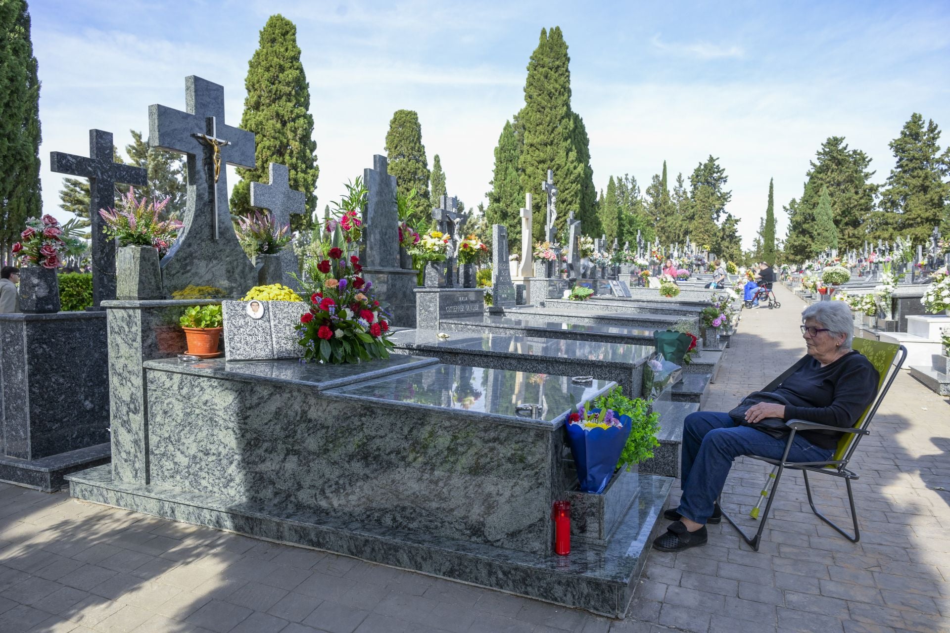 Una mujer a los pies de la tumba de su hijo, ubicada en el cementerio municipal Nuestro Padre Jesús, este sábado en Espinardo, con motivo de la festividad de Todos los Santos.
