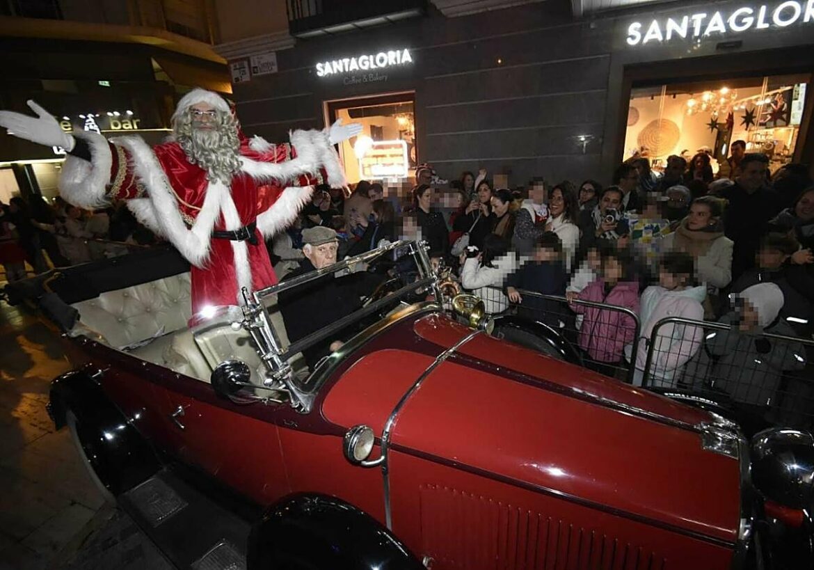 Papá Noel llega a la plaza Belluga de Murcia a bordo de un coche de época