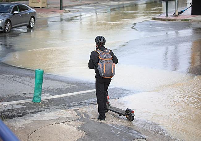 Un joven cruza en patinete la rambla de Churra (Murcia).
