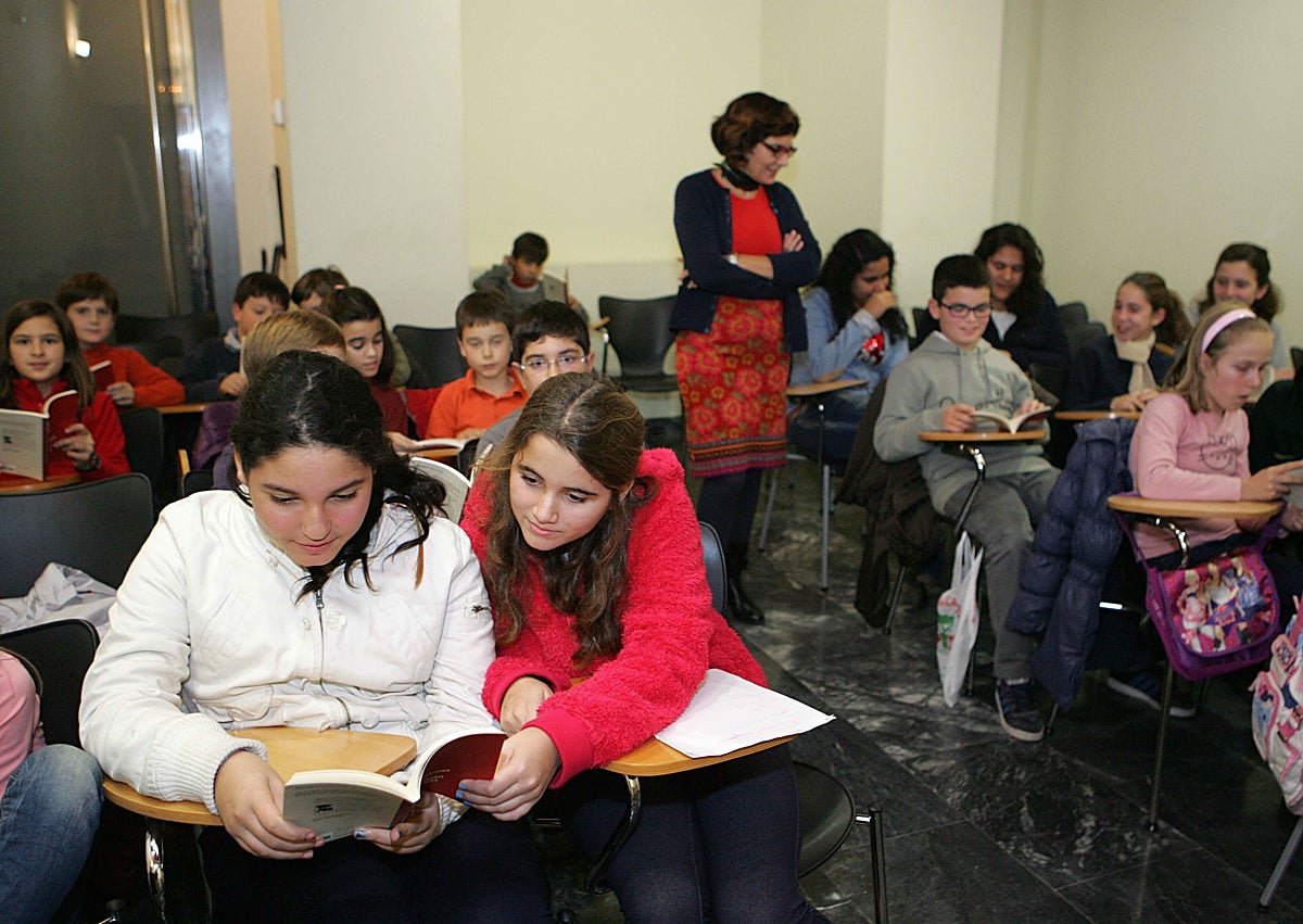 Imagen secundaria 1 - Carlos Egea durante la intervención en el acto de celebración del XX aniversario de La Cometa. En el centro, Marisa López Soria con alumnos de una antigua promoción. En detalle, portada del libro de memorias de Jella Lepman en español, publicadas por Creotz Ediciones en 2017. 