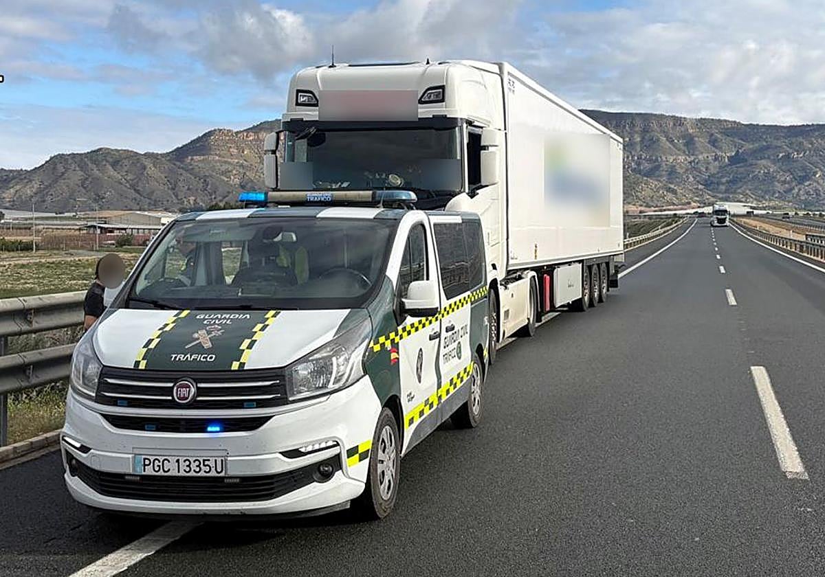 Un vehículo de la Guardia Civil junto al camión detenido.