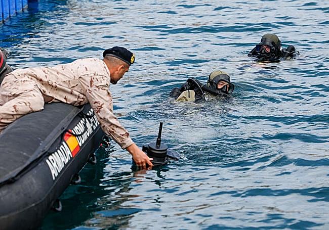 Dos buzos, en el agua, durante una demostración.