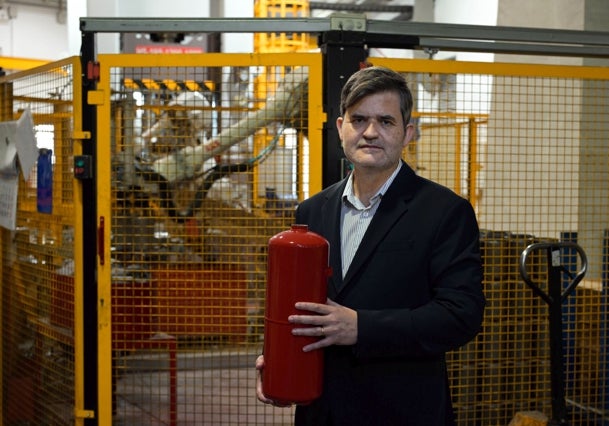 Francisco Chacón, con un envase de extintor, en su fábrica.